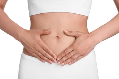 Photo of Healthy digestion. Woman making heart shape with hands near her belly on white background, closeup