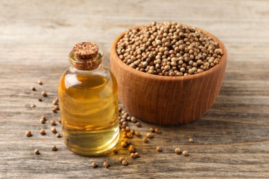 Coriander essential oil and seeds on wooden table