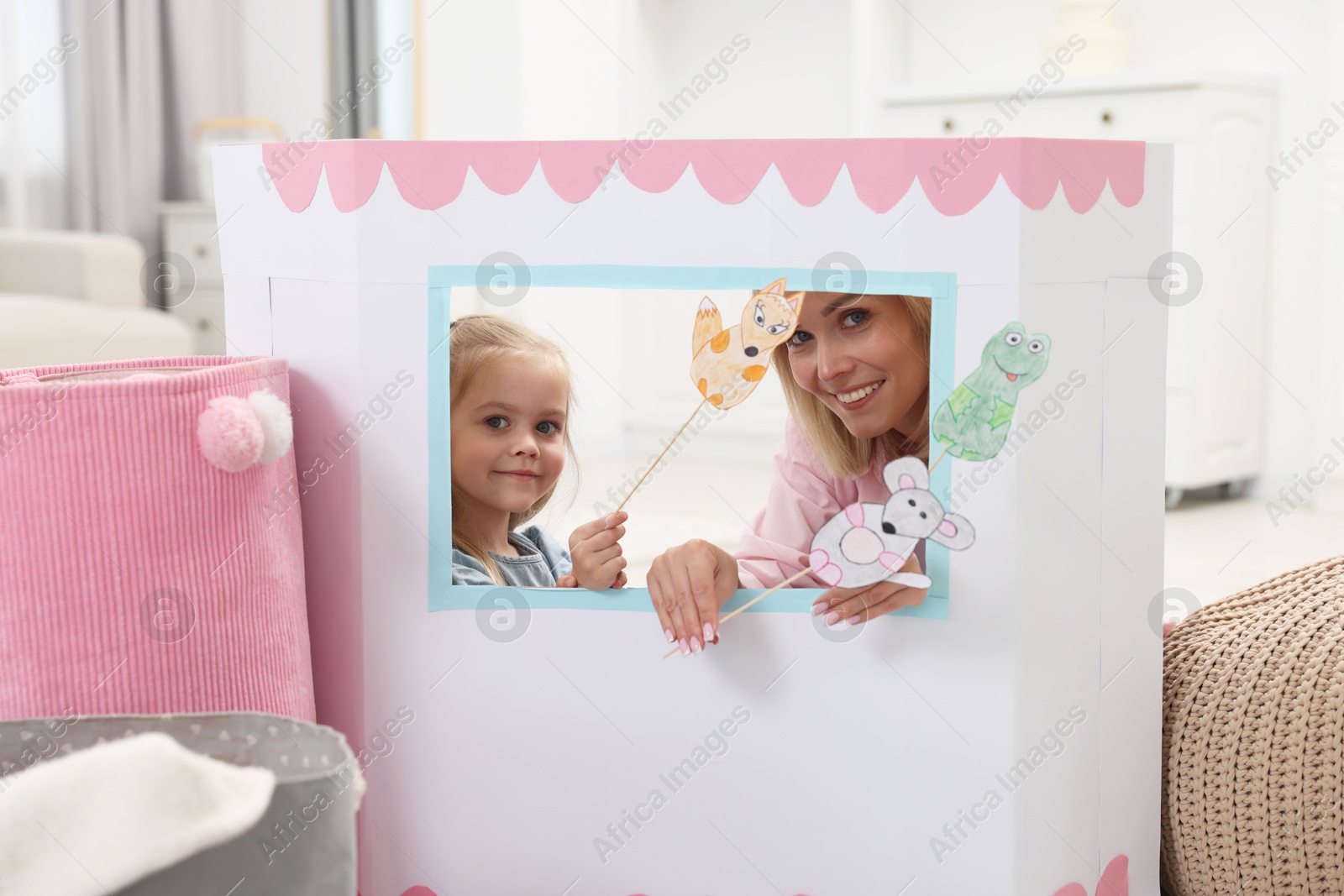 Photo of Mother and daughter performing show in puppet theatre at home