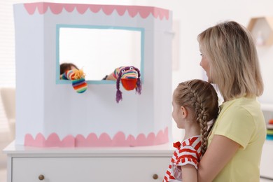 Photo of Mother and daughter watching puppet theatre at home