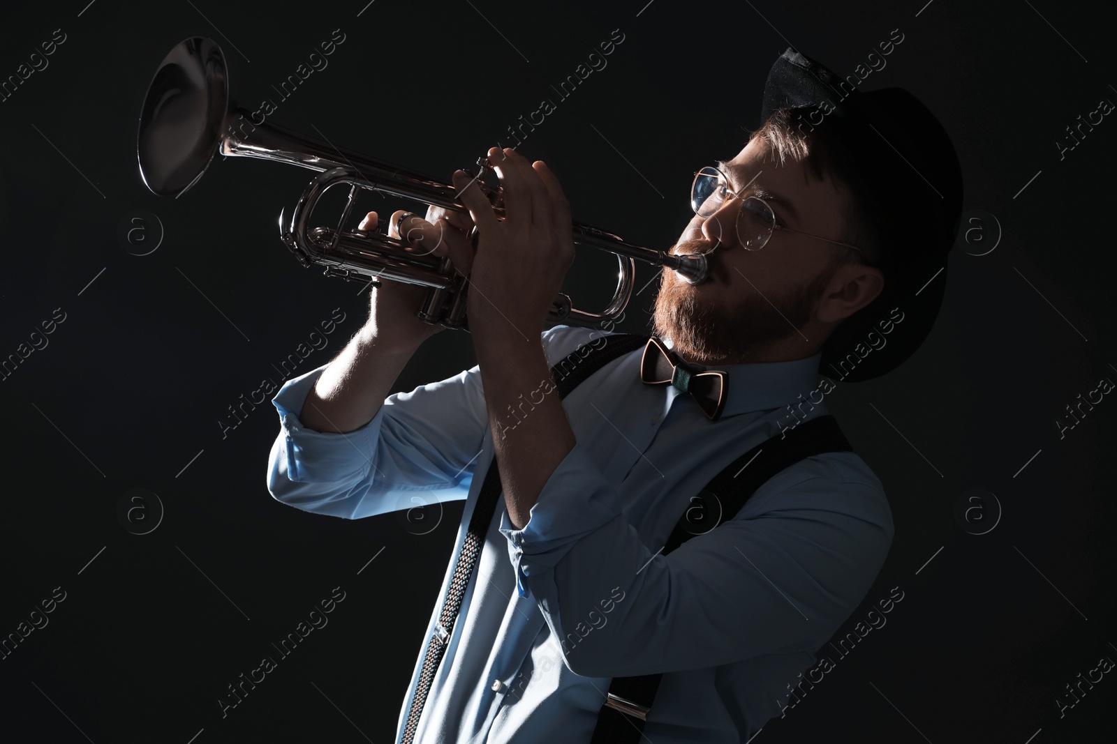 Photo of Professional musician playing trumpet on black background