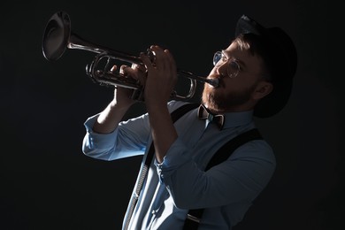 Photo of Professional musician playing trumpet on black background