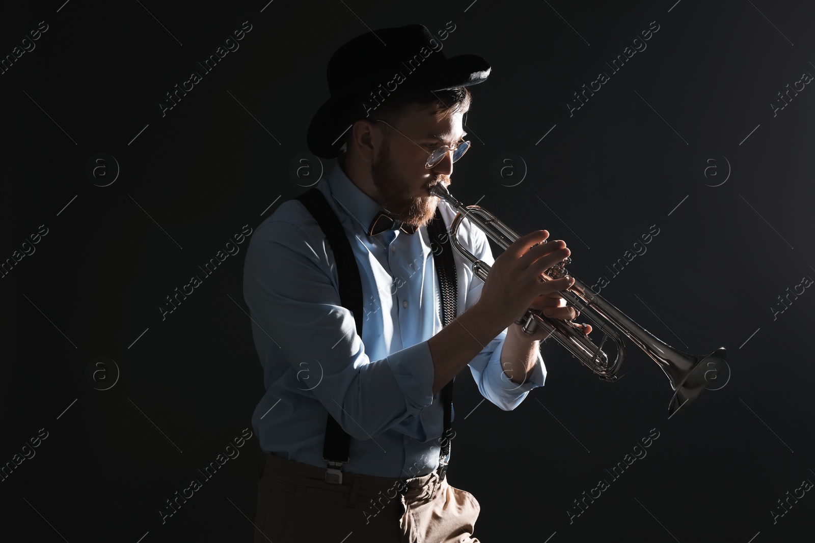 Photo of Professional musician playing trumpet on black background