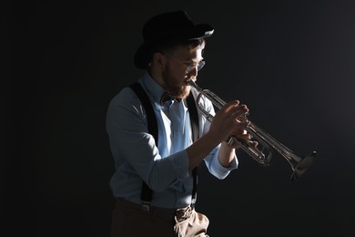 Photo of Professional musician playing trumpet on black background