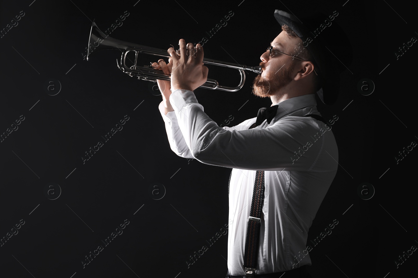 Photo of Professional musician playing trumpet on black background