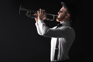 Photo of Professional musician playing trumpet on black background