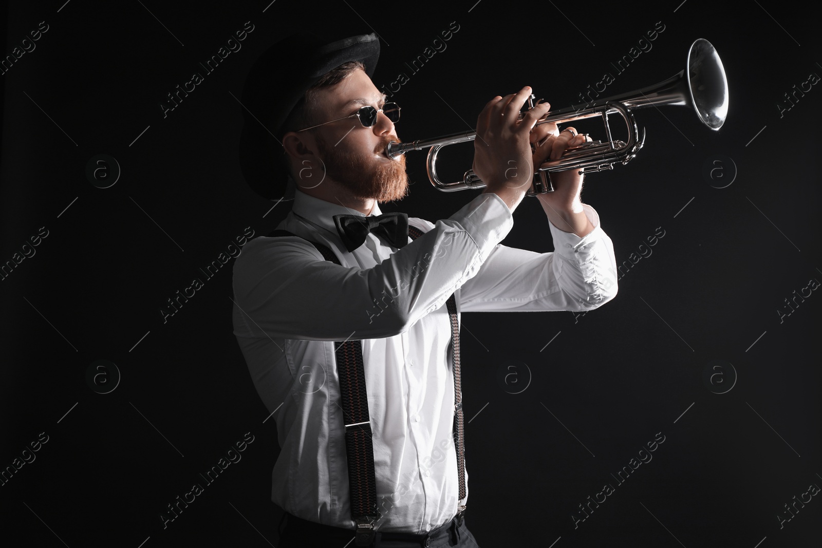 Photo of Professional musician playing trumpet on black background