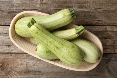 Photo of Raw green zucchinis on wooden table, top view