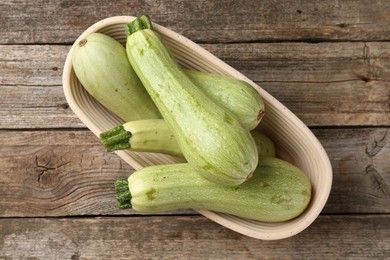 Photo of Raw green zucchinis on wooden table, top view