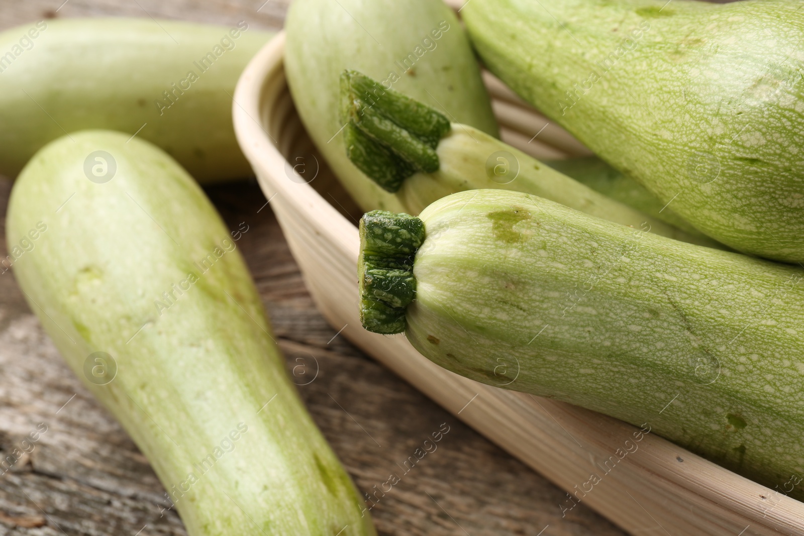 Photo of Raw green zucchinis on wooden table, closeup