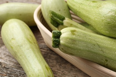 Photo of Raw green zucchinis on wooden table, closeup