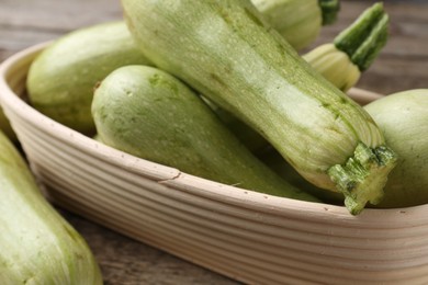 Photo of Raw green zucchinis on wooden table, closeup