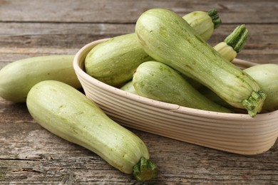 Photo of Raw green zucchinis on wooden table, closeup