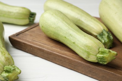 Photo of Raw green zucchinis on white wooden table, closeup