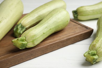 Photo of Raw green zucchinis on white wooden table, closeup