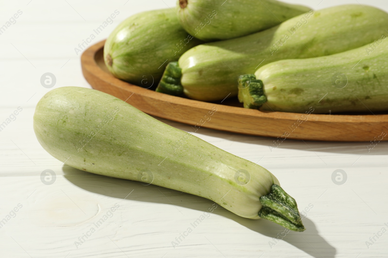 Photo of Raw green zucchinis on white wooden table