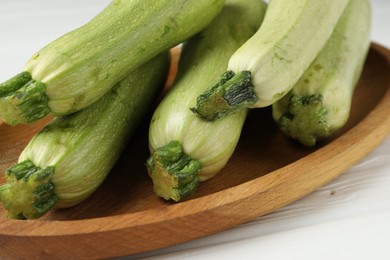 Photo of Raw green zucchinis on white wooden table, closeup