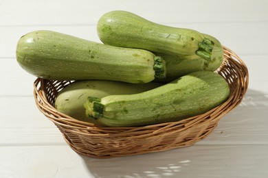 Photo of Raw green zucchinis on white wooden table