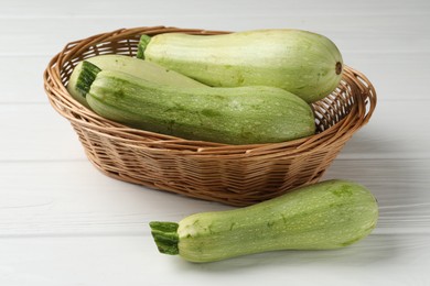 Photo of Raw green zucchinis on white wooden table