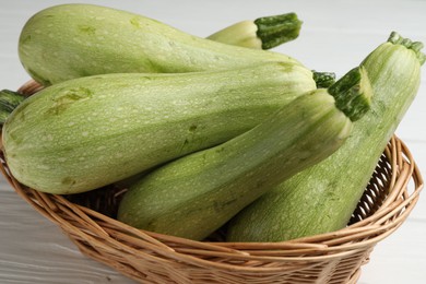 Photo of Raw green zucchinis on white wooden table, closeup