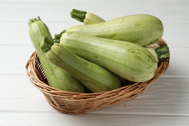 Photo of Raw green zucchinis on white wooden table