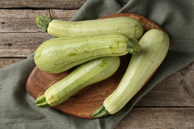 Photo of Raw green zucchinis on wooden table, top view