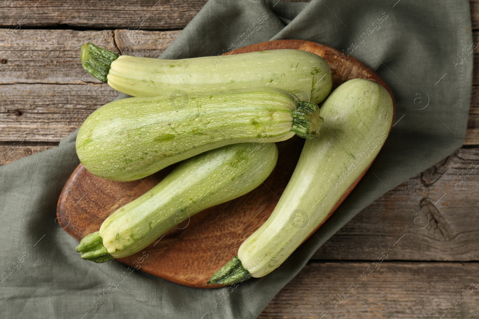 Photo of Raw green zucchinis on wooden table, top view