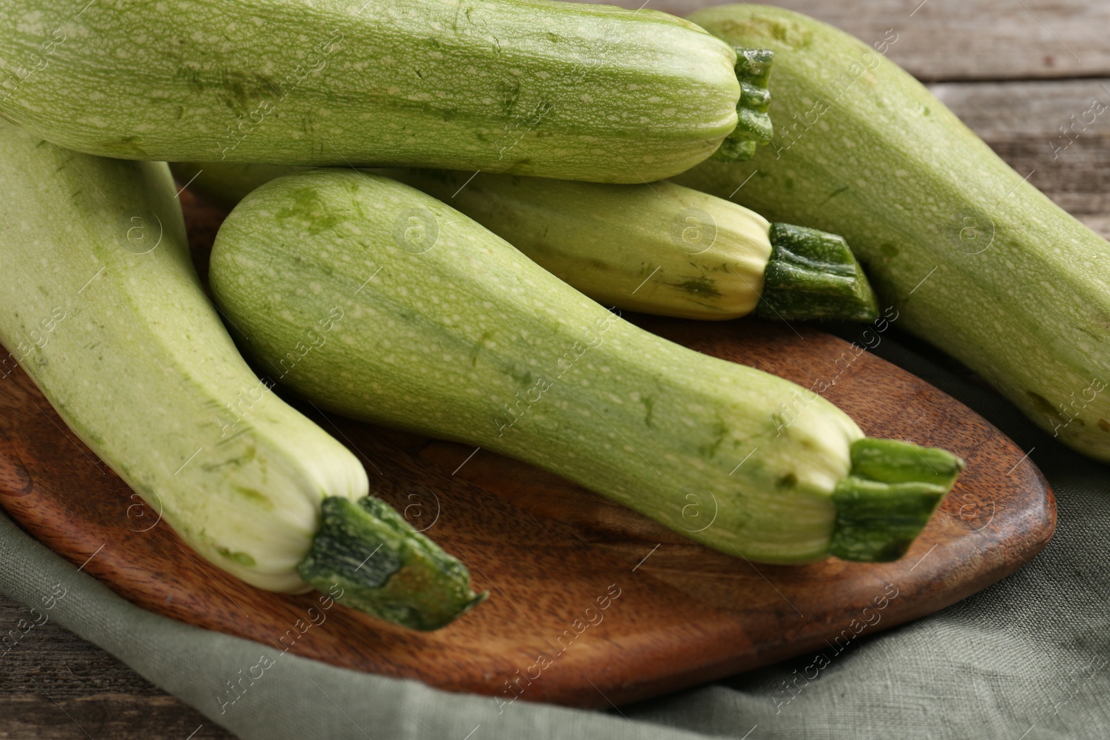 Photo of Raw ripe green zucchinis on table, closeup