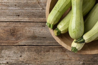 Photo of Raw green zucchinis on wooden table, top view. Space for text