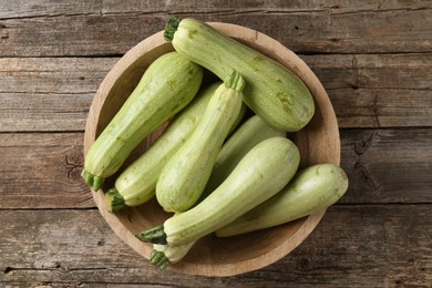 Photo of Raw green zucchinis on wooden table, top view