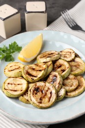 Photo of Tasty grilled zucchini slices served on grey table