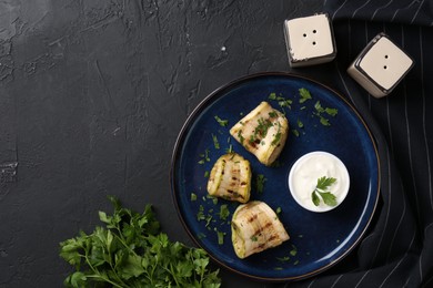 Tasty grilled zucchini slices served on grey textured table, flat lay. Space for text