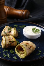 Photo of Tasty grilled zucchini slices served with sauce on table