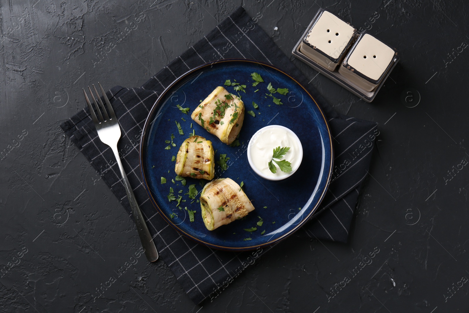 Photo of Tasty grilled zucchini slices served on grey textured table, flat lay