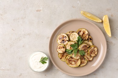 Tasty grilled courgette slices served on grey textured table, flat lay. Space for text