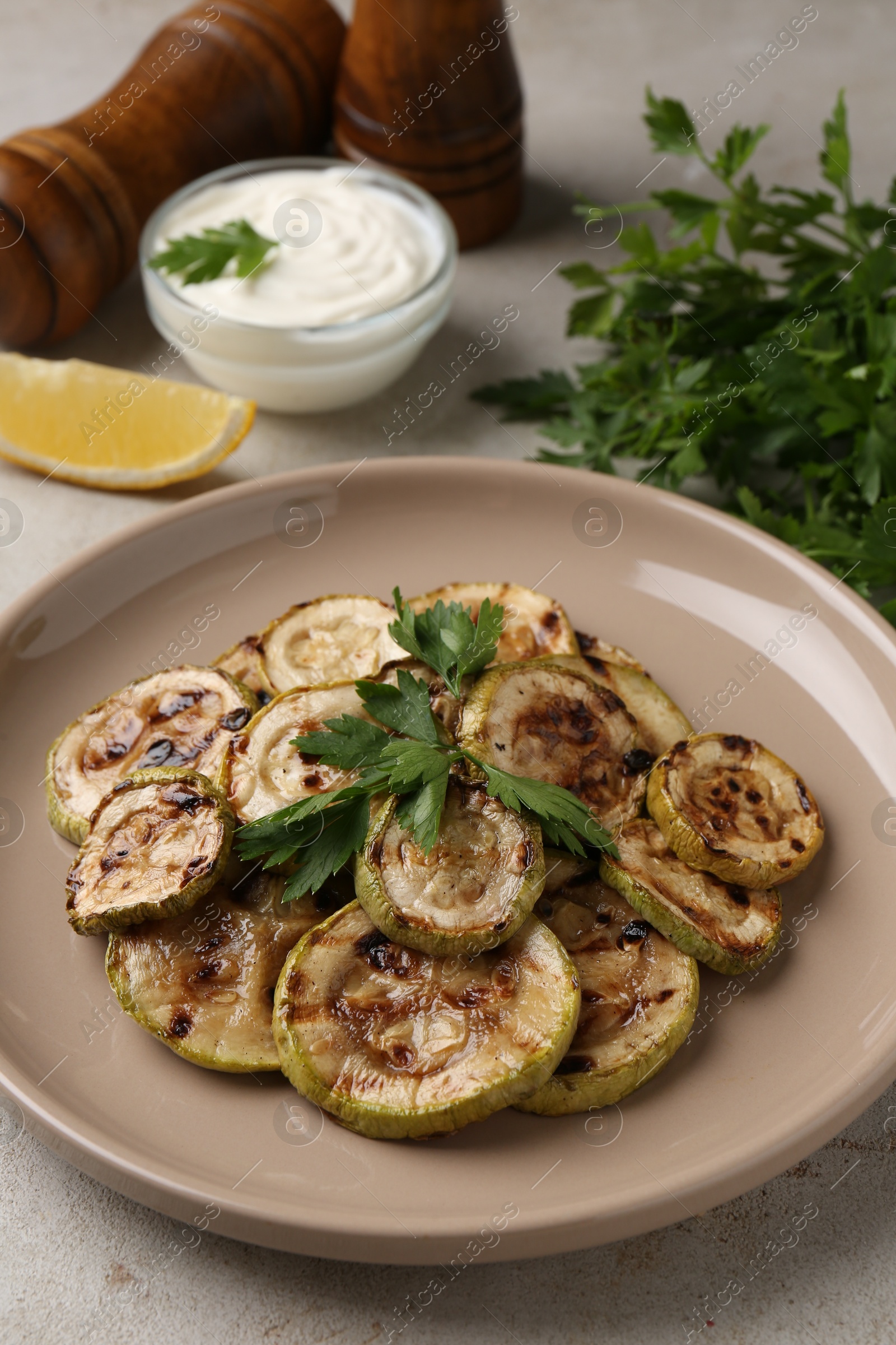 Photo of Tasty grilled courgette slices with parsley on grey table