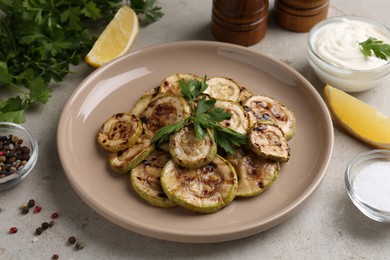 Photo of Tasty grilled courgette slices served on grey table