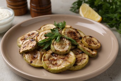 Photo of Tasty grilled courgette slices with parsley on grey table