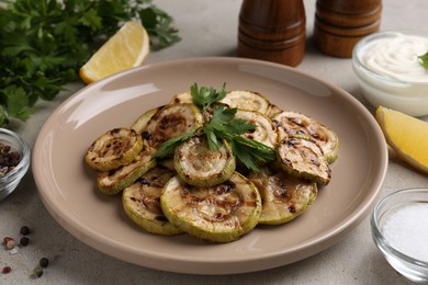 Photo of Tasty grilled courgette slices served on grey table