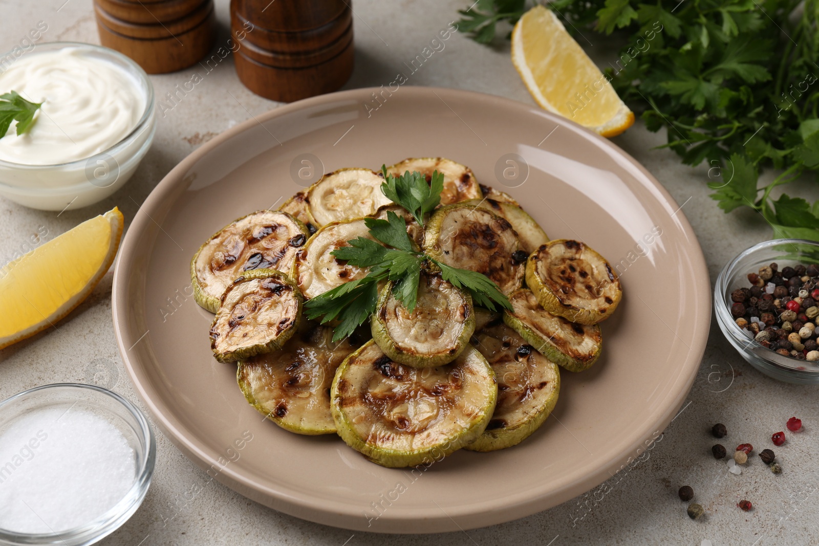 Photo of Tasty grilled courgette slices served on grey table