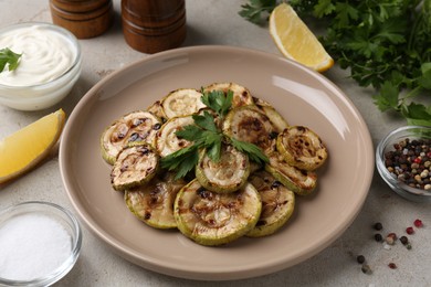 Tasty grilled courgette slices served on grey table