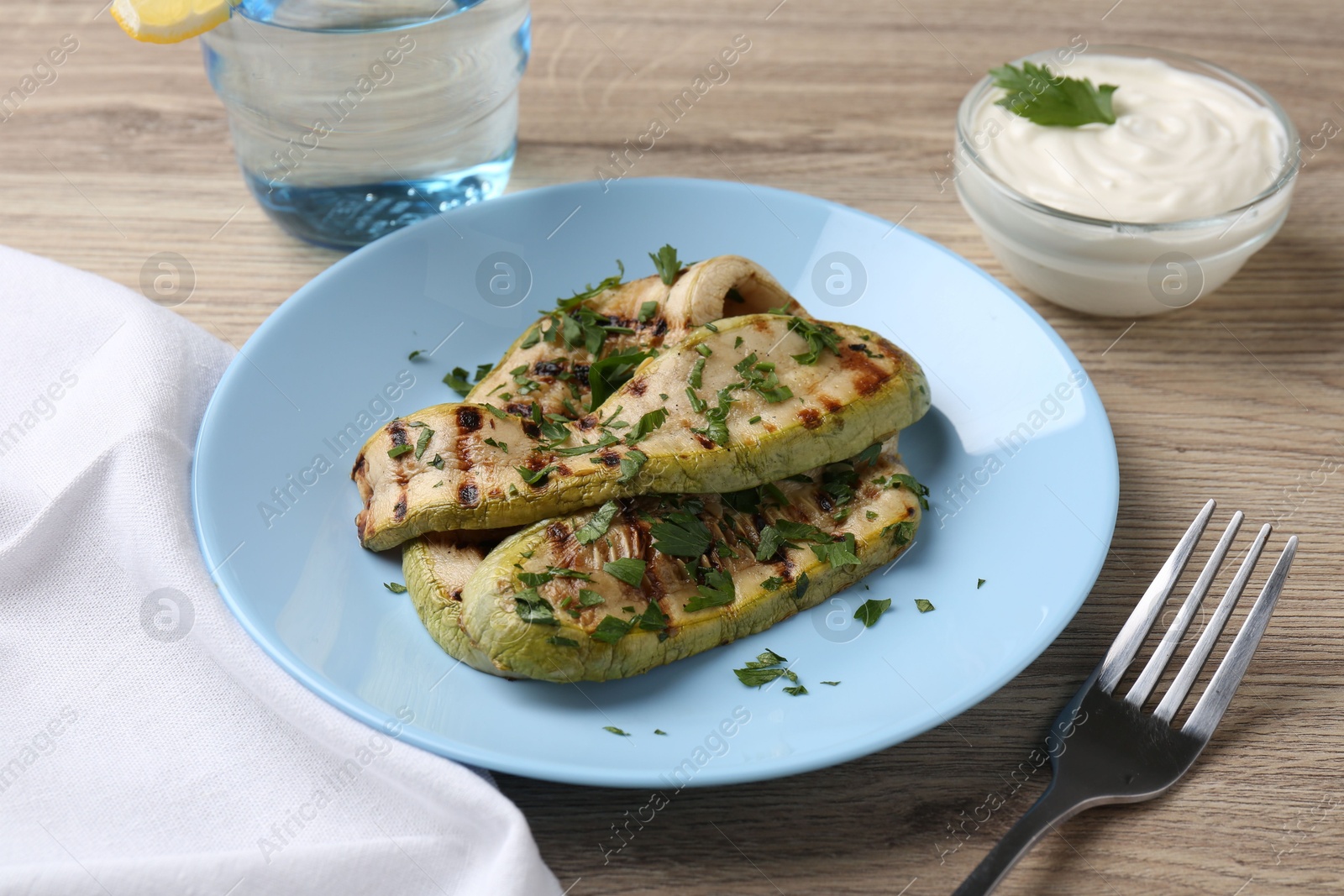 Photo of Tasty grilled courgette slices served on wooden table