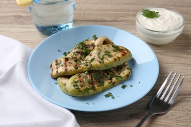 Photo of Tasty grilled courgette slices served on wooden table