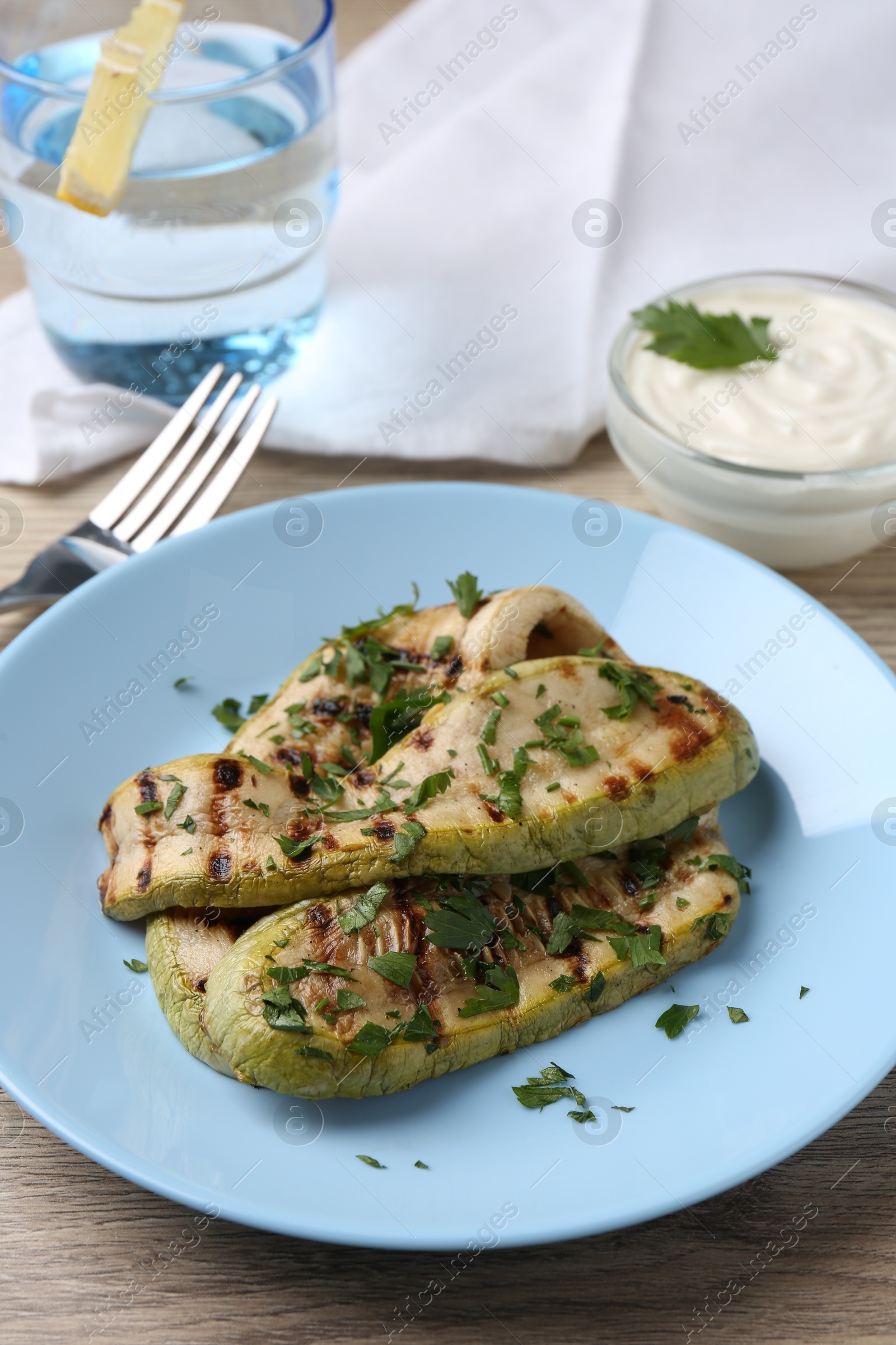 Photo of Tasty grilled courgette slices served on wooden table