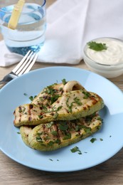 Tasty grilled courgette slices served on wooden table