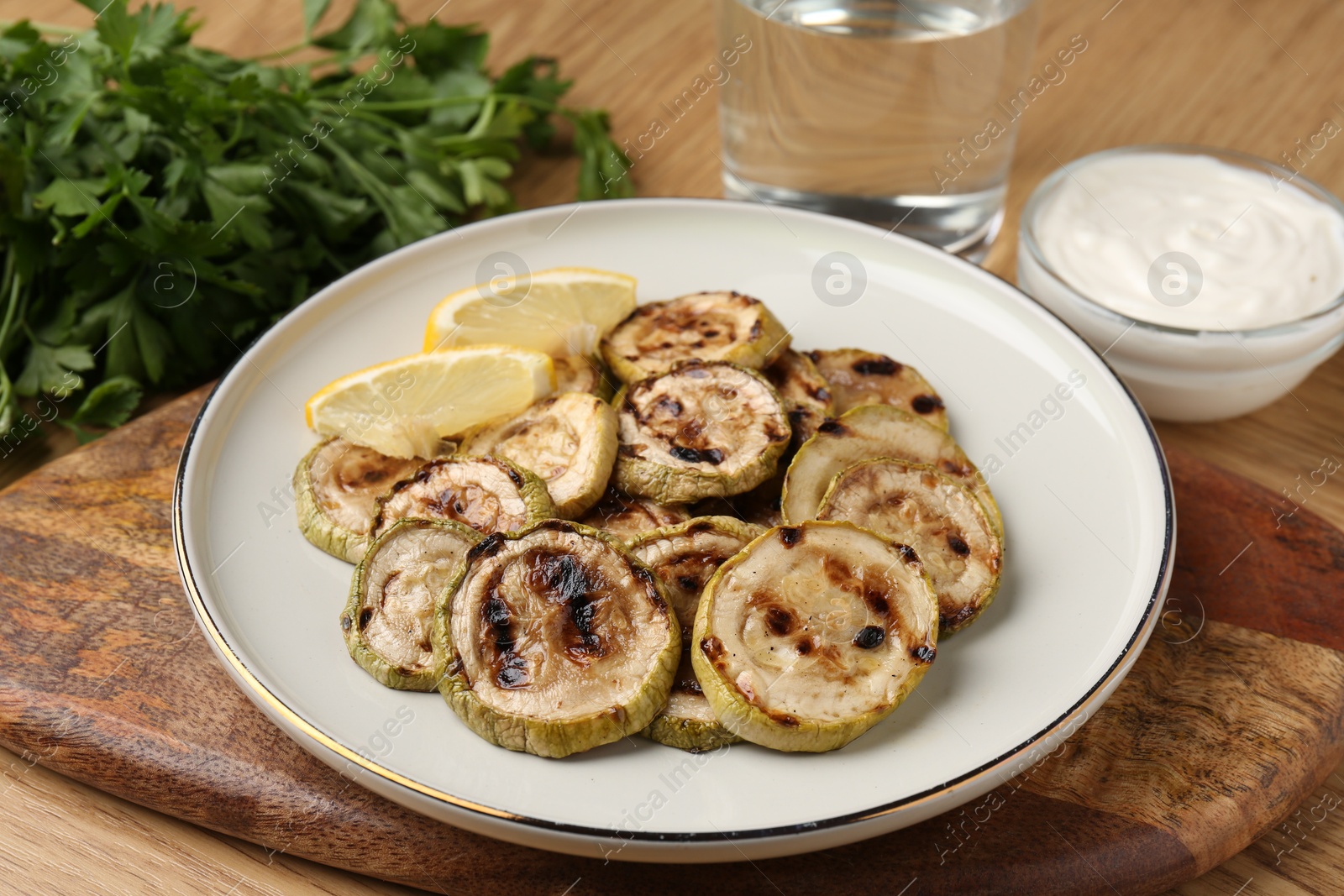 Photo of Tasty grilled courgette slices served on wooden table