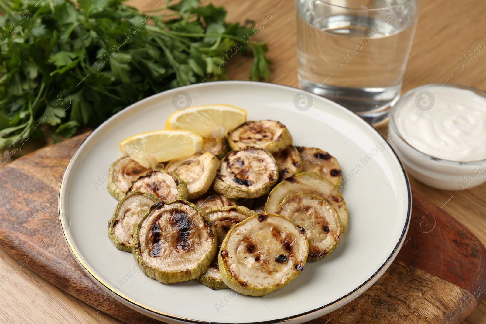 Photo of Tasty grilled courgette slices served on wooden table