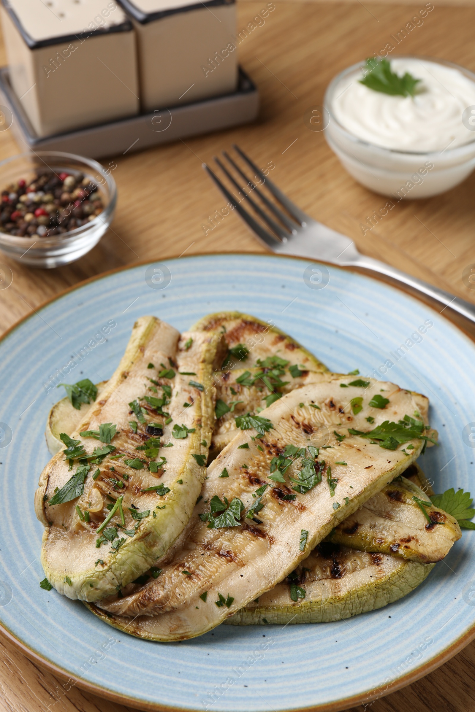 Photo of Tasty grilled courgette slices served on wooden table