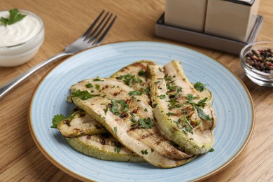 Tasty grilled courgette slices served on wooden table