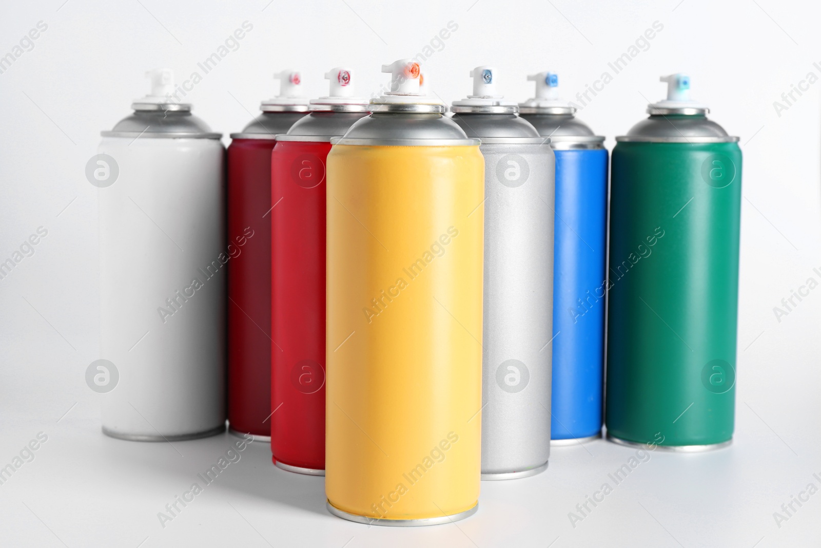 Photo of Cans of spray paint on white background